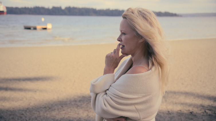 وقفت باميلا أندرسون ، التي تم تصويرها هذا العام ، على شاطئ يطل على البحر.