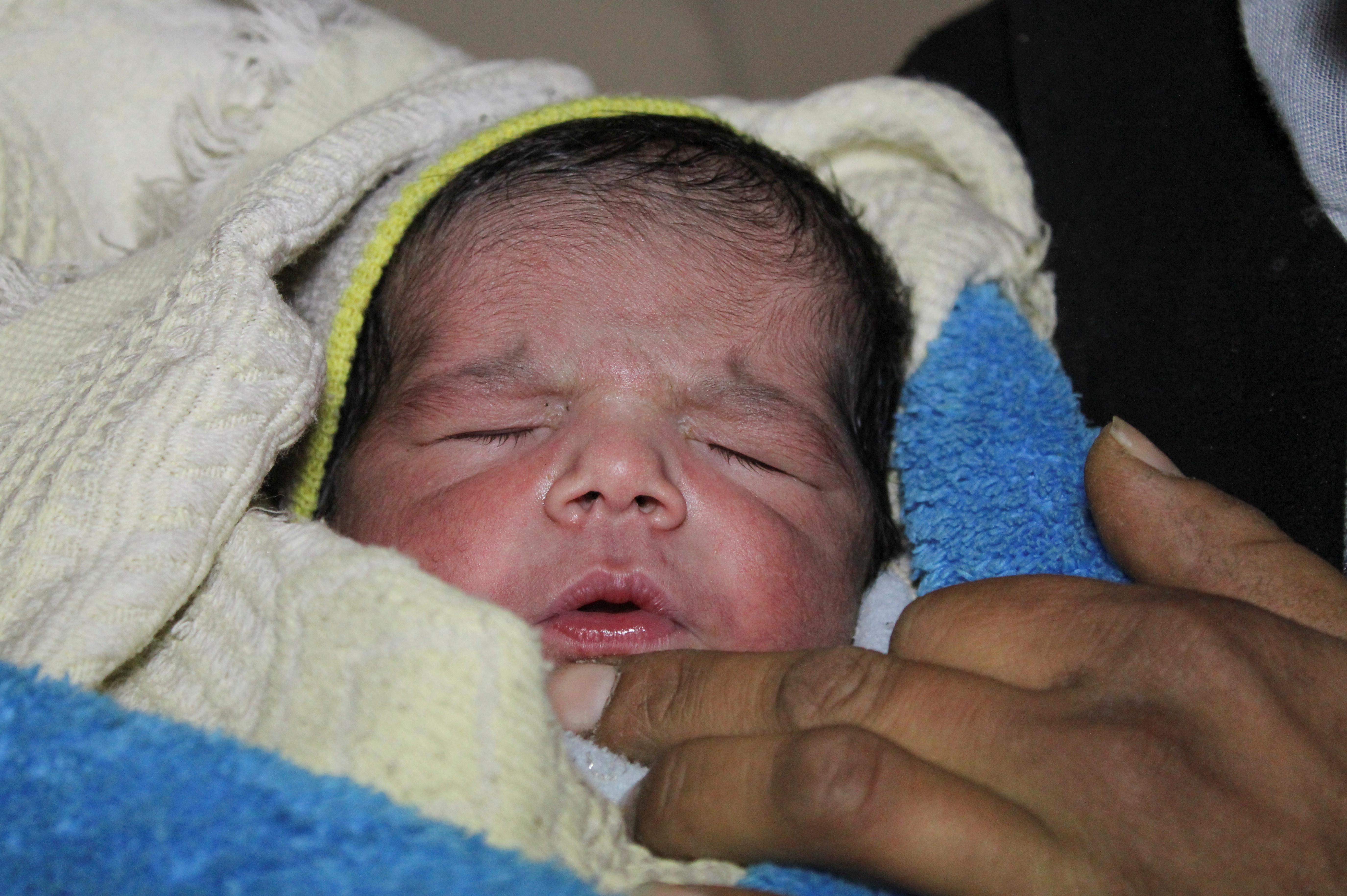 فاطمة أحمد تحمل مولودها الجديد نجم الدين محمود في حلب