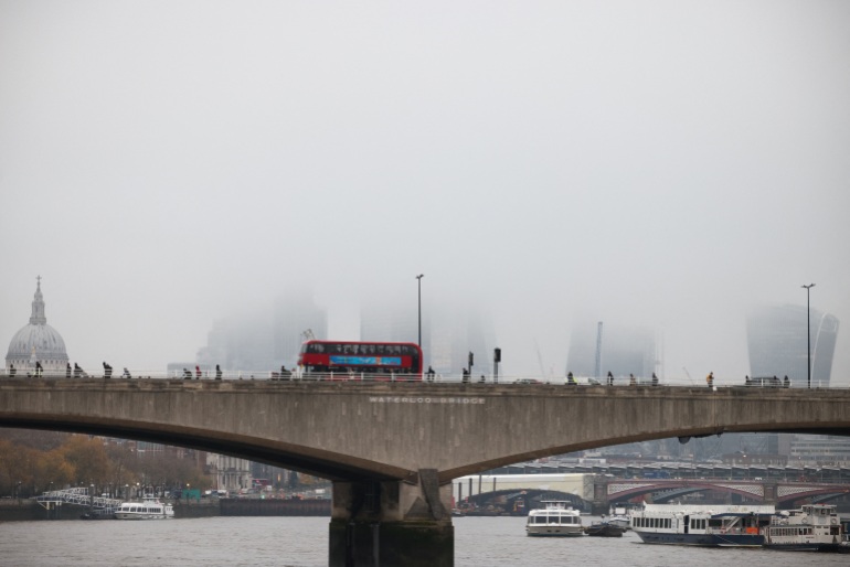 People walk over Waterloo Bridge during foggy weather in London